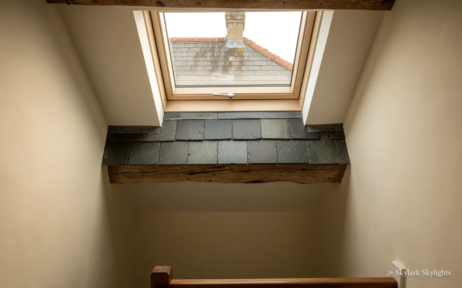 Shadowy space beneath a roof window with a dark ledge