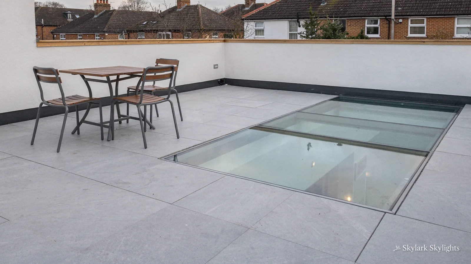 Roof terrace with a table and chairs beside a walk-on glass panel