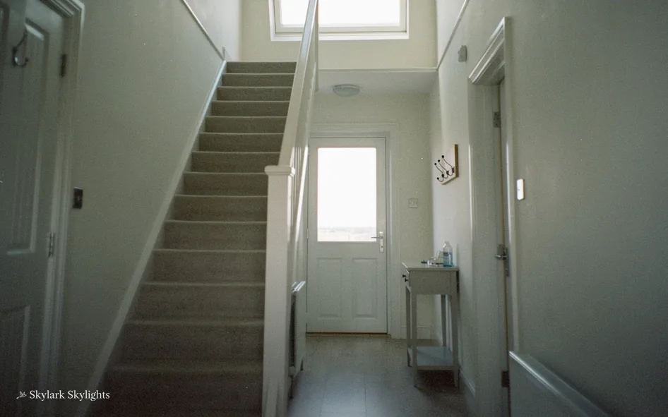 Hallway with stairs and a glazed front door