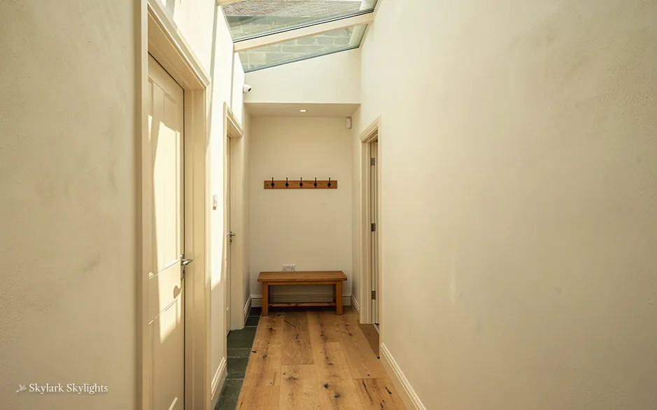Narrow hallway with a bench and a rooflight above