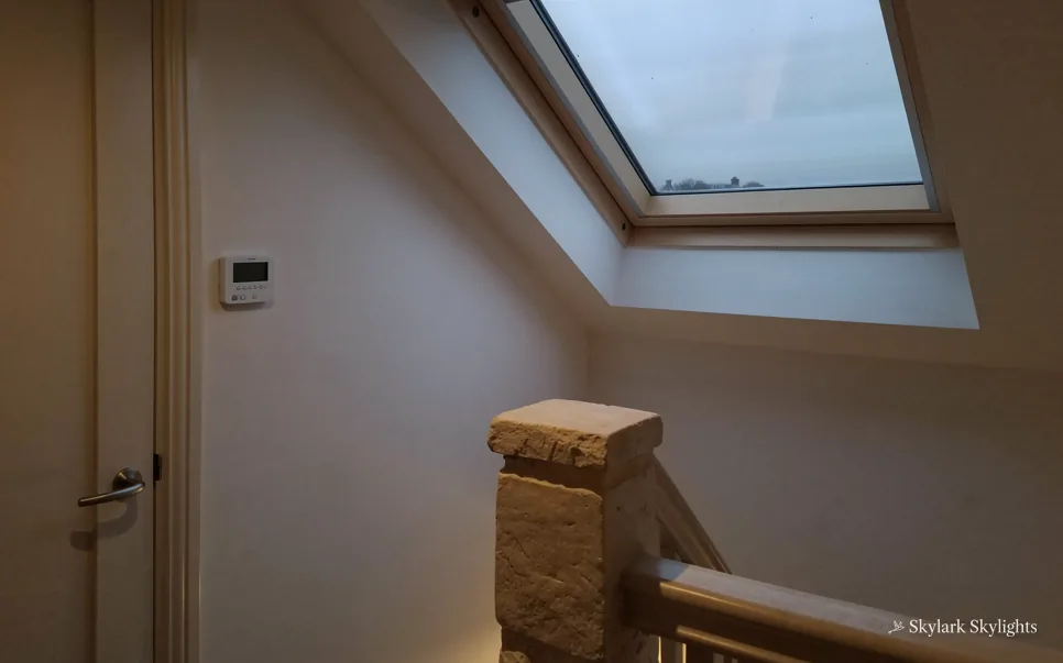 Top of a staircase with a newel post under a sloping ceiling