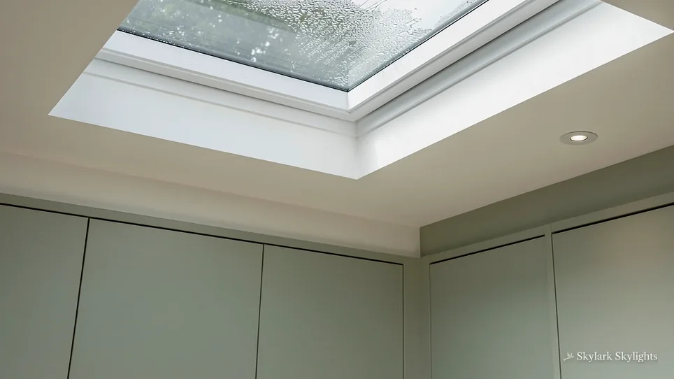 Rooflight in a white ceiling with raindrops on the glass