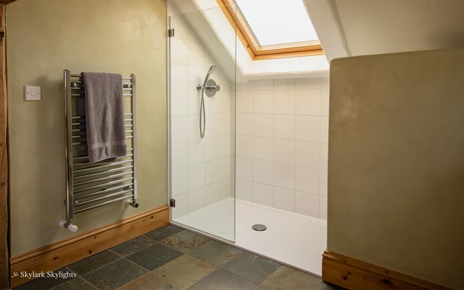 Shower room with a towel rail and a small roof window