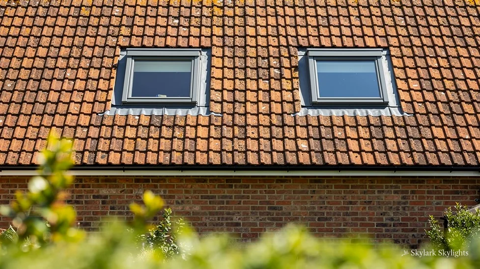 Two roof windows in a red-tiled roof