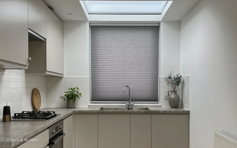 Kitchen with a blind drawn over the window above the sink