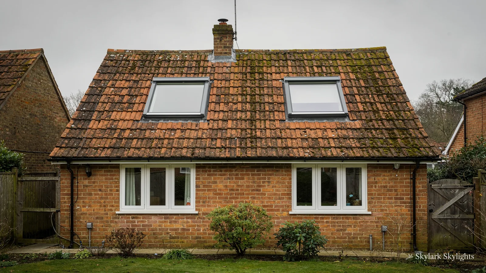 Brick bungalow with a red-tiled roof and two roof windows