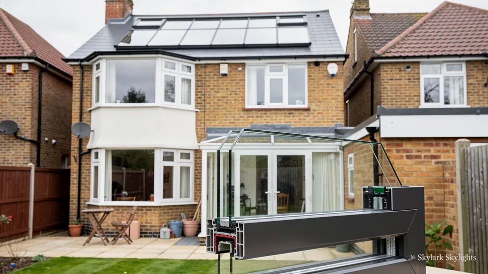 Rear of a brick semi with a glazed extension and roof windows