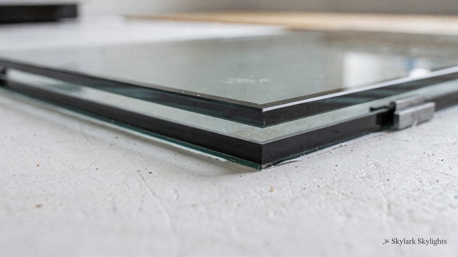 Edge of a multi-pane glazing unit resting on a pale surface