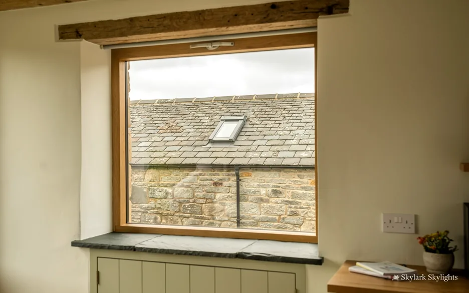 Deep window with a wide sill looking onto a stone wall