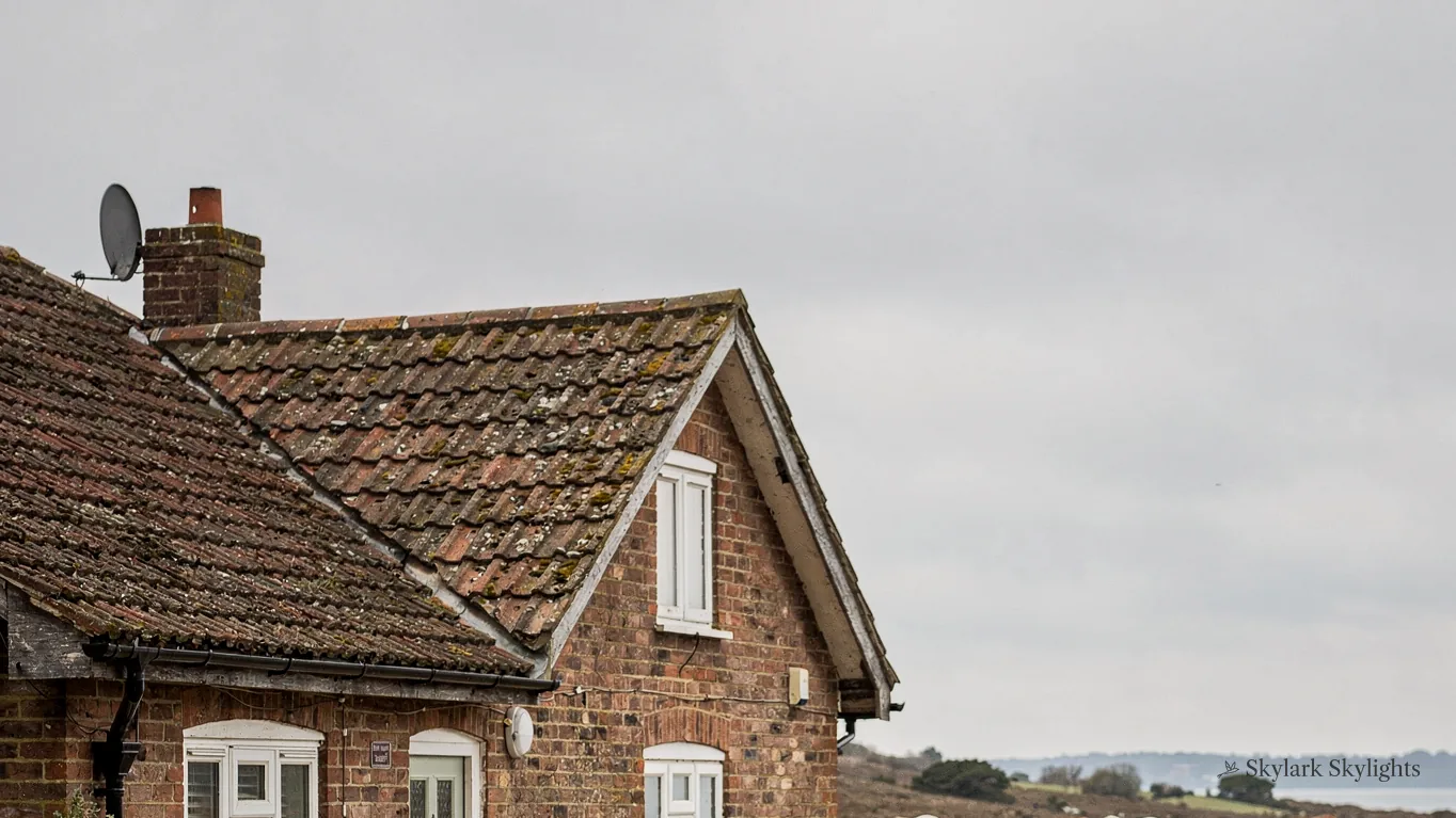 Gable end of a brick cottage with a clay-tiled roof