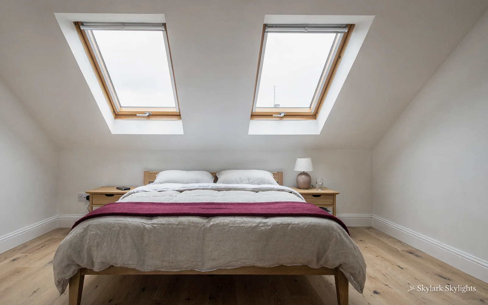 Loft bedroom with two roof windows above the bed