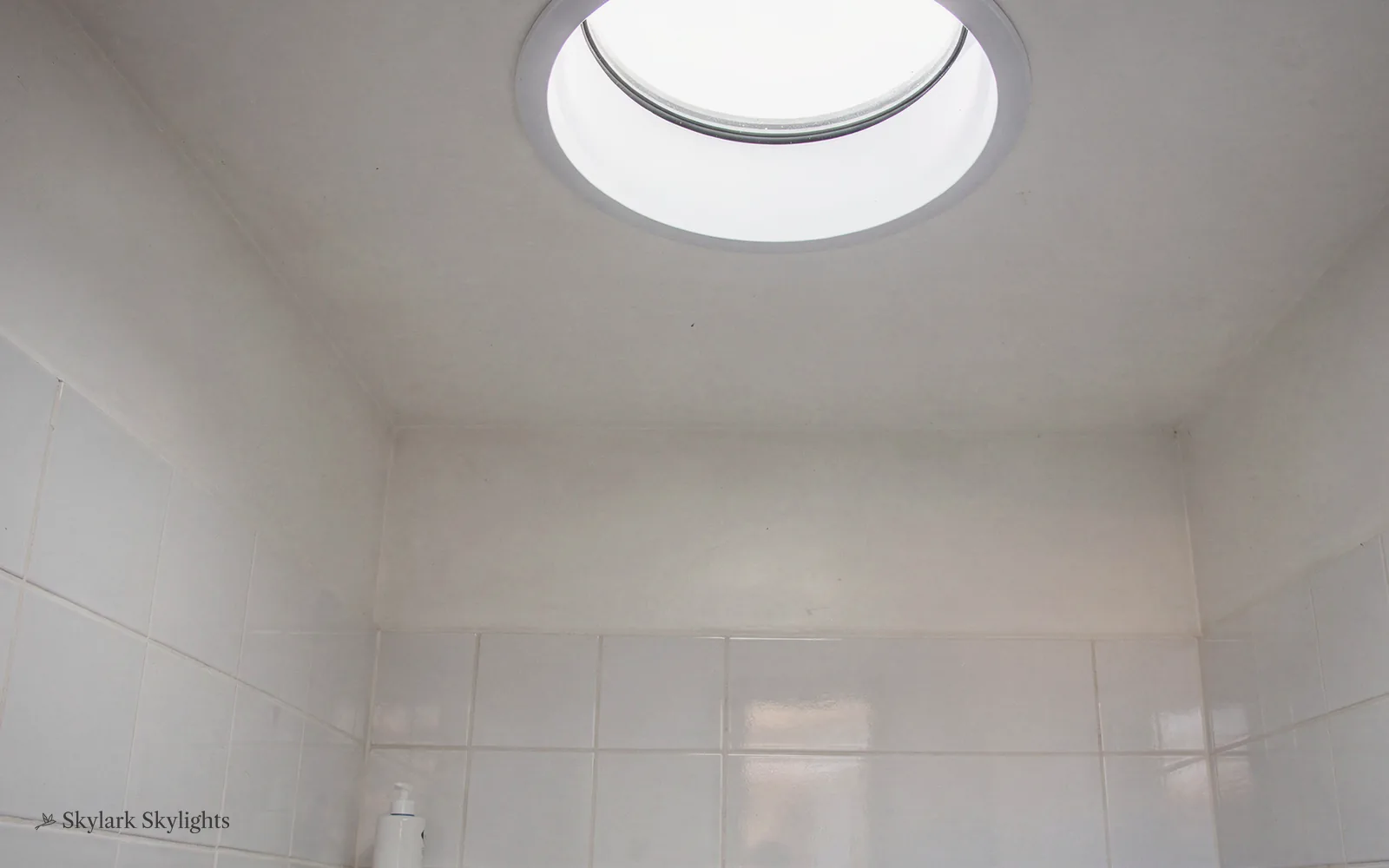 Tiled room lit by a round sun tunnel diffuser
