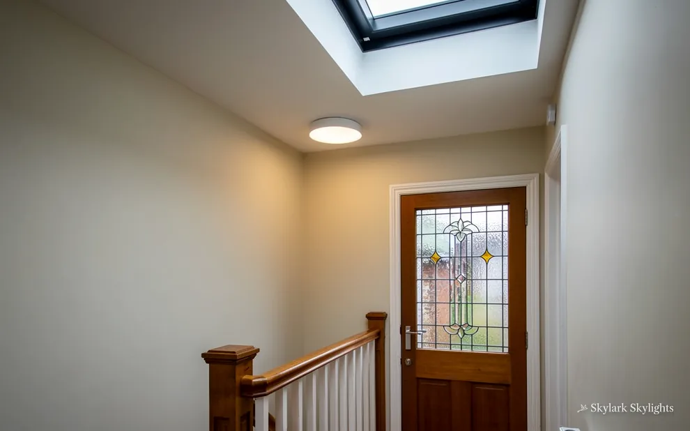 Landing with a stained-glass door and a sun tunnel above
