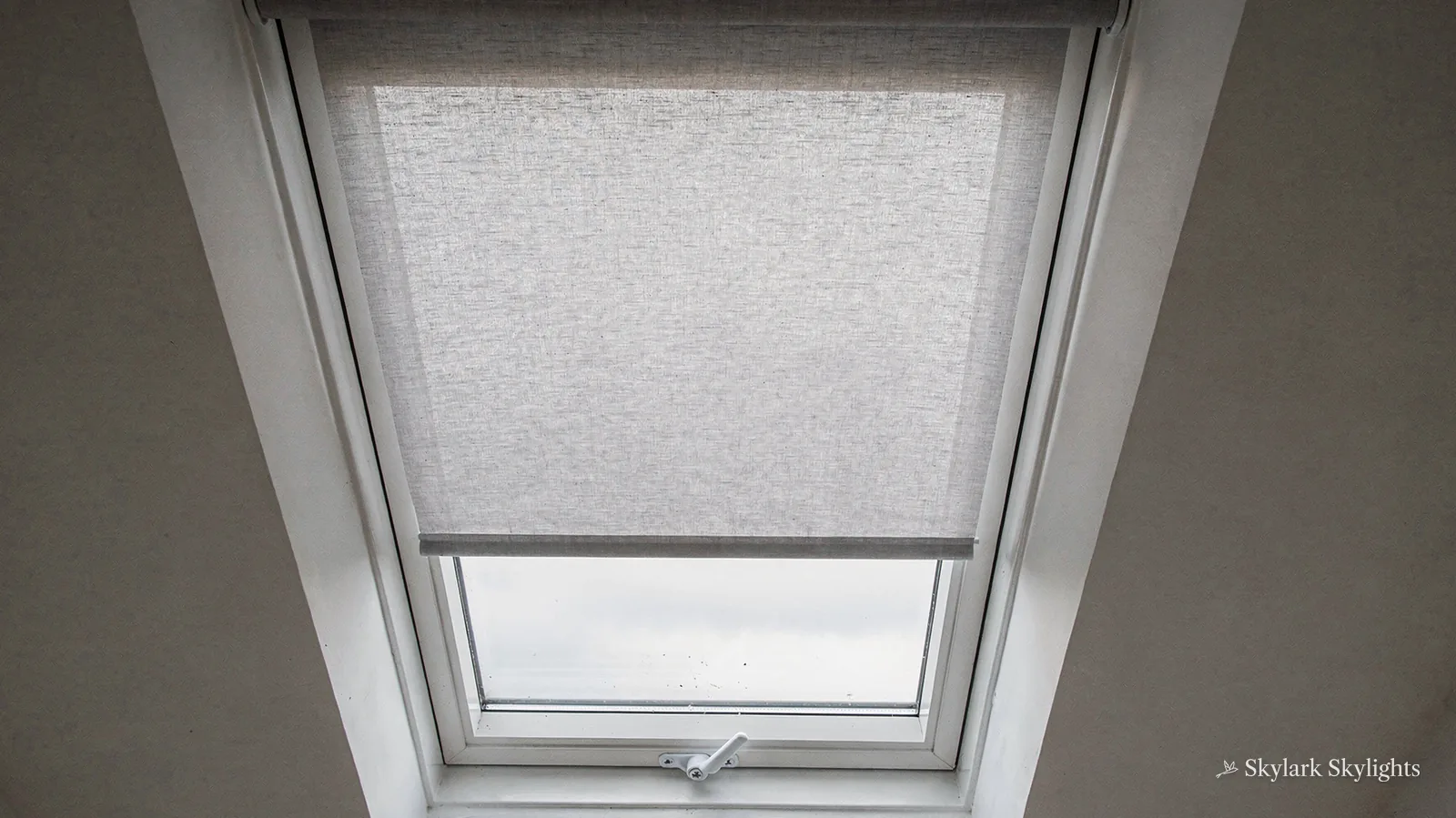 Roof window with a pleated blind drawn across it