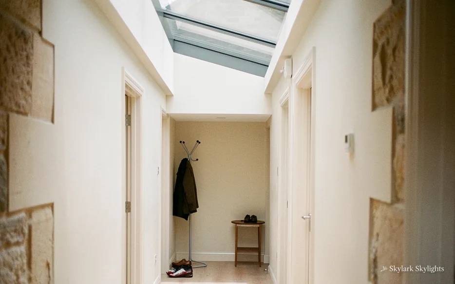 Narrow hallway with a coat on a peg and a rooflight above