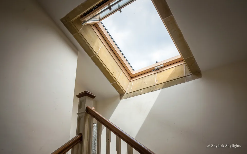 Stair landing with a roof window in the sloping ceiling