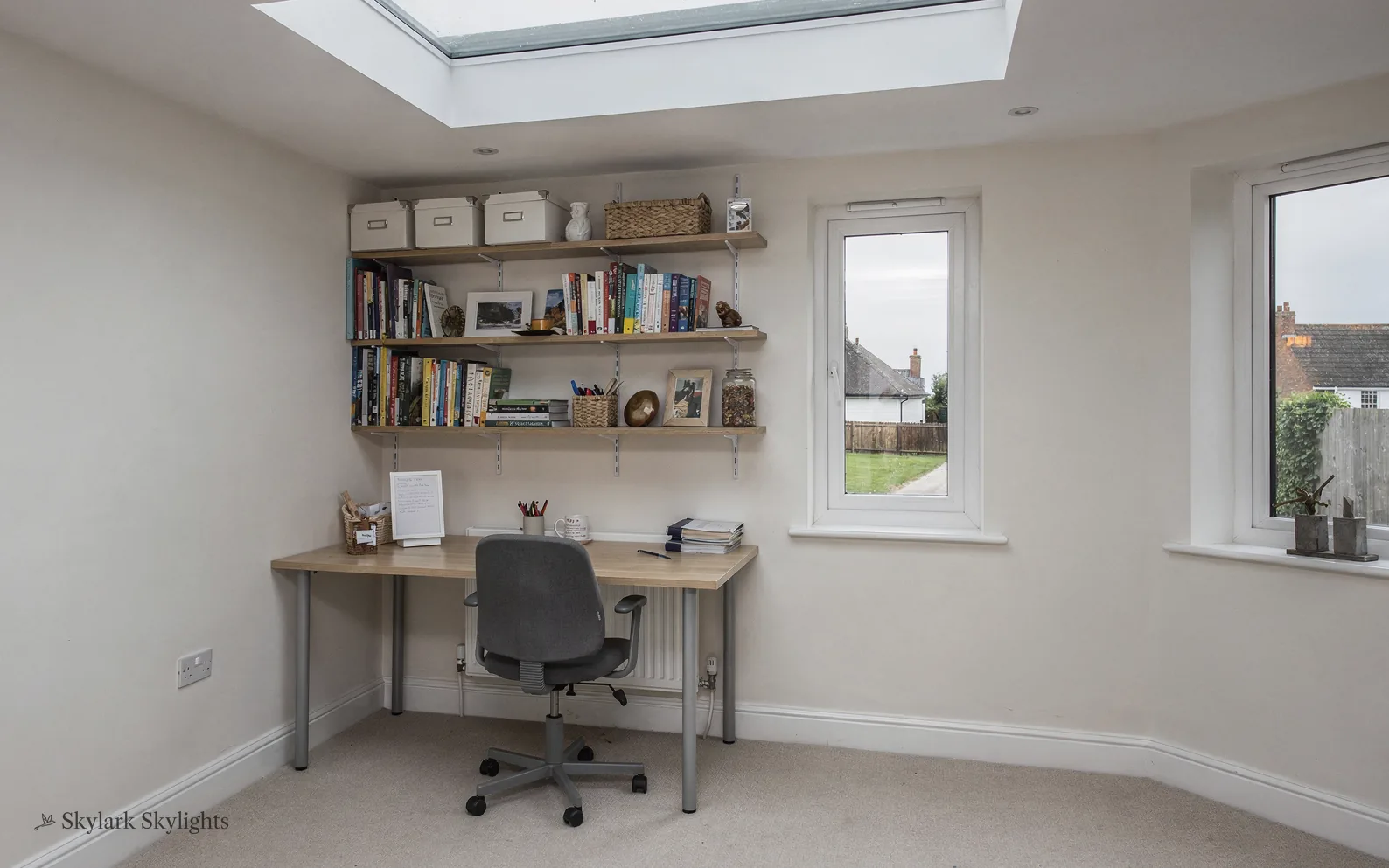 Box room set up as a study with a desk and shelves