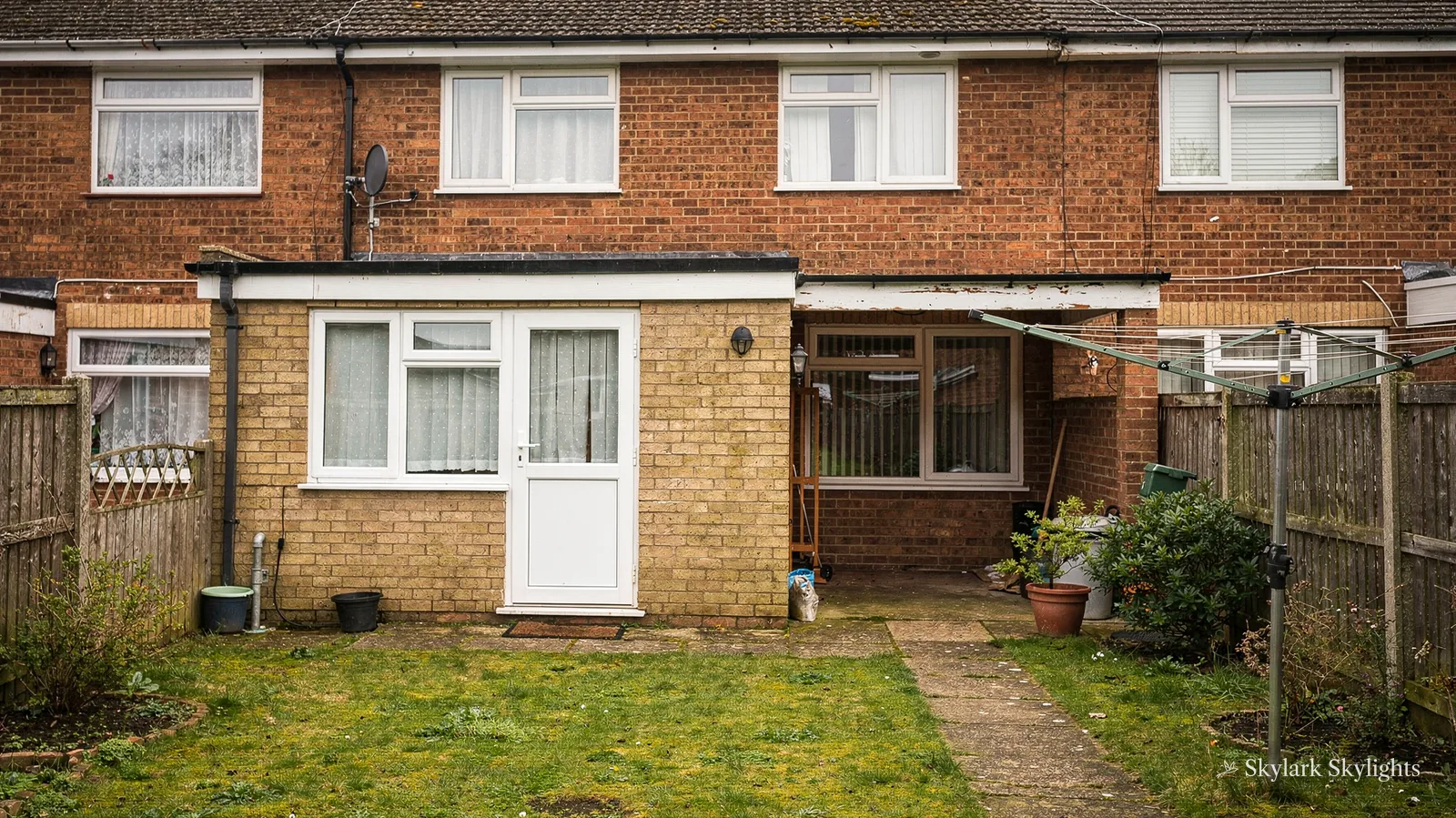 Rear of brick semis with a single-storey extension and lawn