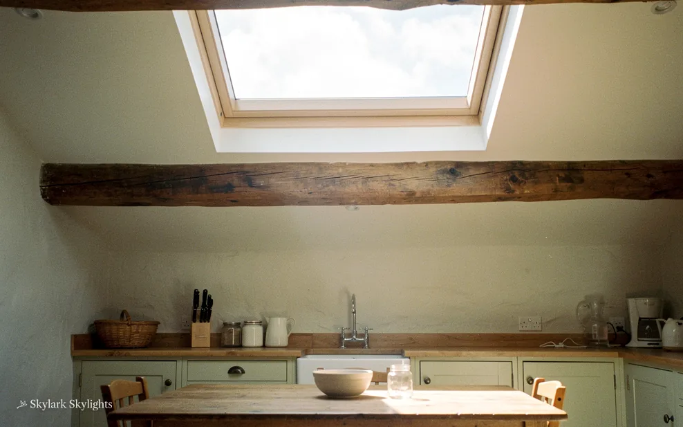 Kitchen worktop beneath a beam and a roof window