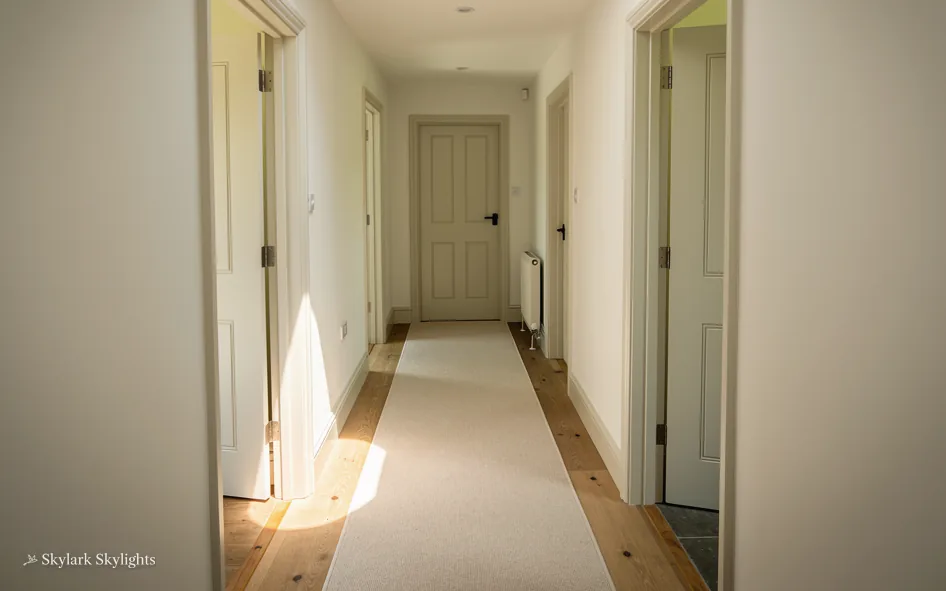 Long upstairs corridor with a runner and doors on both sides
