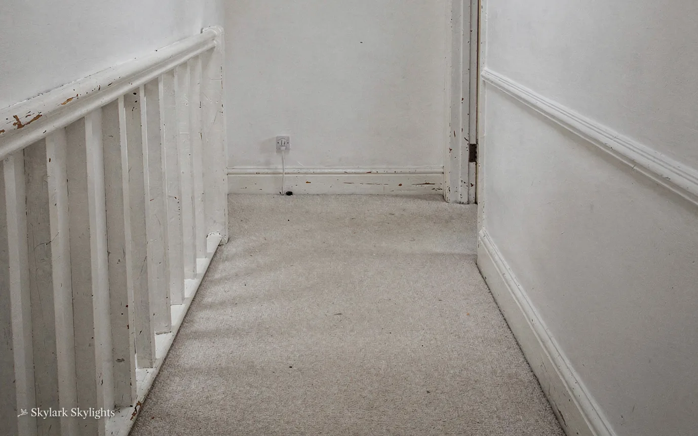 White banister running along a narrow landing