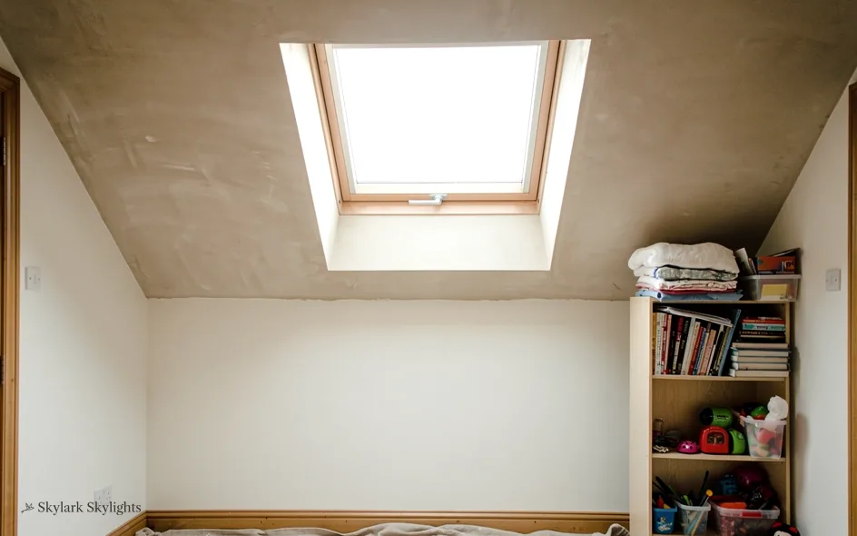 Bookcase under a roof window in a sloping room