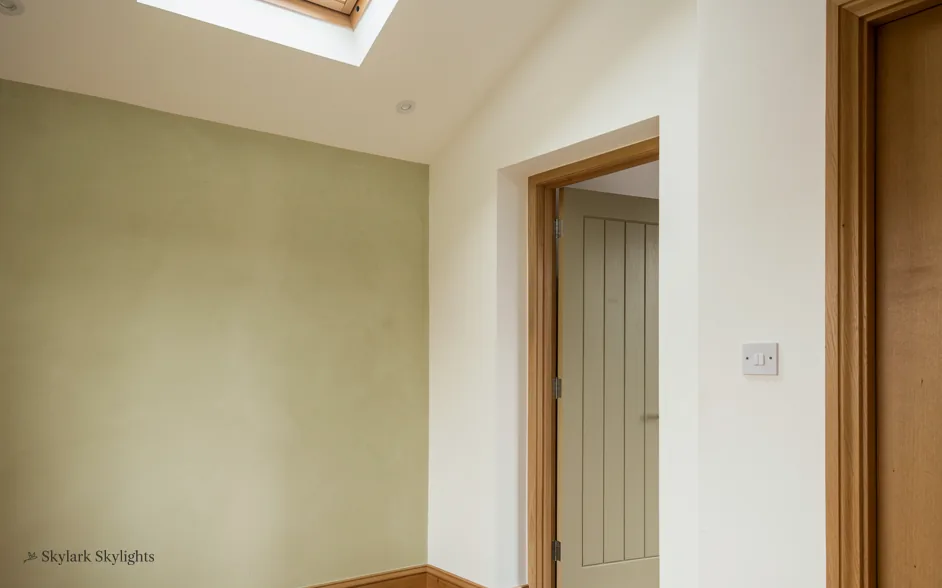 Plain hallway with a closed door and a light switch