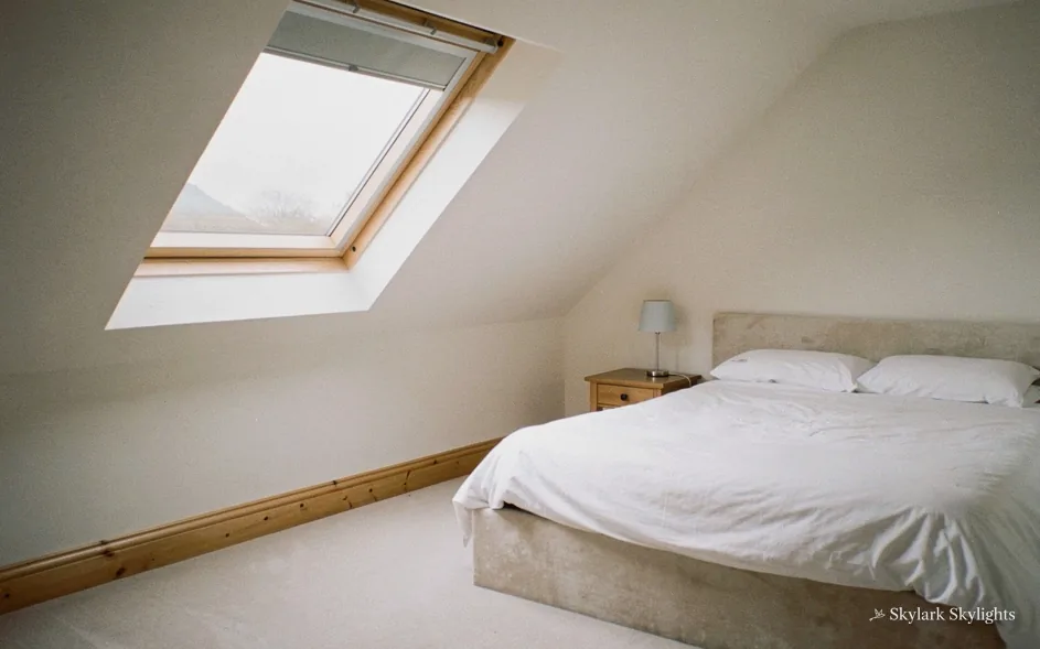 Bed below a roof window in a loft bedroom