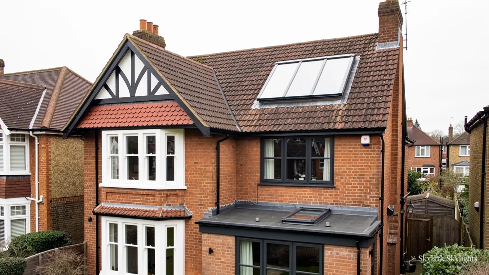 Mock-Tudor brick semi with a roof window and a bay at the front