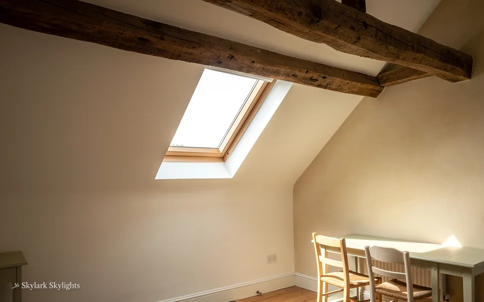 Sloping loft ceiling with an old beam and a small roof window