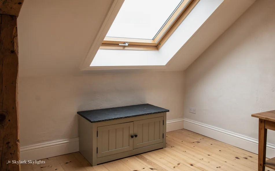 Storage bench under a roof window in a loft